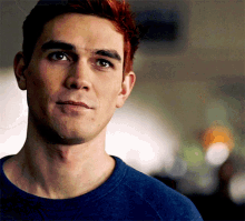 a man with red hair is wearing a blue sweater