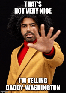 a man in a yellow coat is making a stop gesture