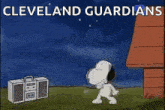 a cartoon of snoopy dancing in front of a radio with the words `` cleveland guardians '' written on it .