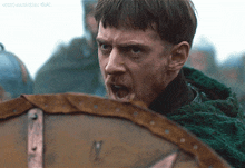 a close up of a man holding a shield with the word lord written on the bottom right