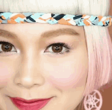a close up of a woman 's face with a braided headband and pink earrings