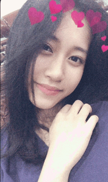 a girl with hearts on her hair is smiling for the camera