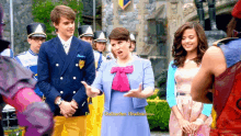 a woman in a blue dress is talking to a man in a suit with the words i 'm fiery godmother headmistress