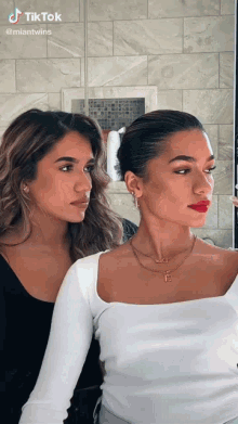 two women are standing next to each other in front of a mirror with tiktok written at the top