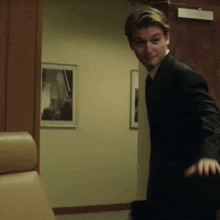 a man in a suit is standing in a hallway