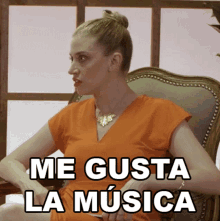 a woman in an orange dress sits in a chair with the words me gusta la musica written on the bottom