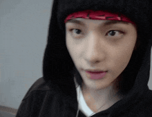 a close up of a person wearing a hoodie and a headband .