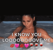 a woman is sitting in a hot tub with two glasses of red wine and hearts .