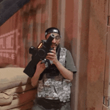 a man holding a gun in front of a wall that has the word pubg on it