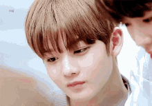 a close up of a young boy 's face with the letters mg on the bottom right corner