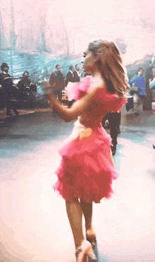 a woman in a pink dress dancing on a stage