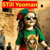 a little boy wearing sunglasses and a rasta hat is smiling .