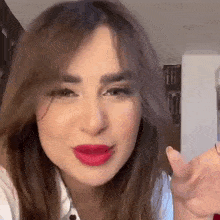 a close up of a woman 's face with red lipstick .