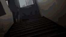 a person is walking down a set of stairs in a dark room