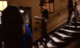 a man is standing on a set of stairs reading a book to a woman .