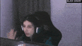 a woman wearing headphones is sitting at a desk in front of a computer screen .