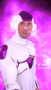 a man in a white costume with a purple background has a tiktok sticker