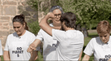 a group of people wearing t-shirts that say no planet b