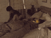 two people laying on a bed with a lamp on the nightstand