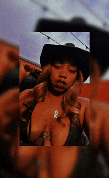 a woman wearing a cowboy hat and a necklace that says ' sss ' on it