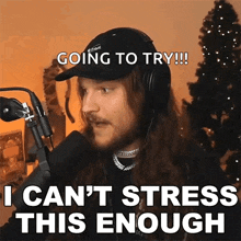 a man wearing headphones and a hat says going to try i can t stress this enough