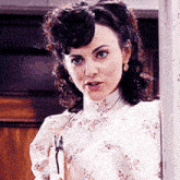 a woman in a white dress holds a gun