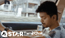 a man sitting in a car with a star tamil chat logo on the bottom
