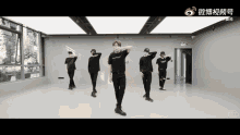 a group of young men are dancing in a room with chinese writing