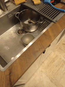 a stainless steel kitchen sink with a pot and a bowl in it