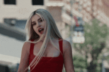 a blonde woman in a red dress is singing