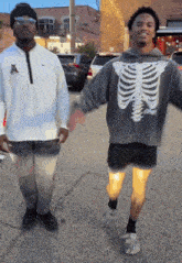 a man wearing a skeleton sweatshirt is dancing with another man
