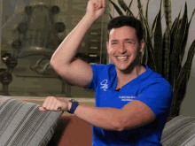 a man wearing a blue shirt that says ' dr. alfred frederick ' on the front