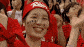 a woman wearing a red headband with the word korea on her face