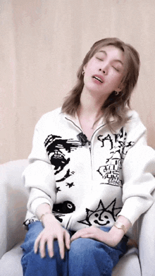 a woman wearing a sweater that says " save " on it sits on a couch