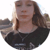 a girl wearing a shirt that says may 22im looks at the camera