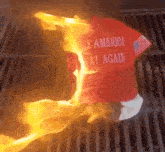a shirt that says " make america at again " is burning on a grill