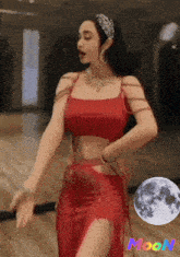 a woman in a red dress is dancing in front of the moon