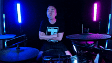 a man wearing a black shirt with the letter n on it is playing drums