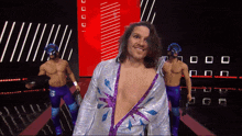a wrestler in a purple and silver outfit has the number 5 on his pants