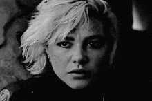 a black and white photo of a woman 's face with blonde hair .