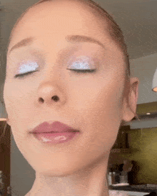 a close up of a woman 's face with eyes closed
