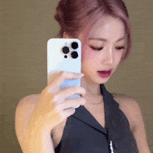 a woman with pink hair is taking a selfie with her cell phone