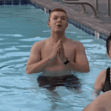 a shirtless man is praying in a pool