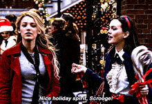 two women are standing next to each other and one of them says nice holiday spirit scroogee
