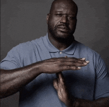 a man in a blue shirt is clapping his hands