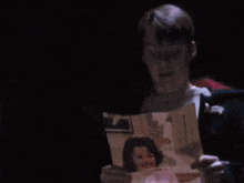 a couple of men are looking at a picture of a woman .