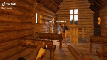 a person is holding a lighter in a video game in front of a log cabin .