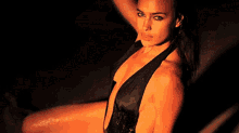 a woman in a very revealing black top is sitting down
