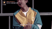 a man wearing a yellow and blue jacket with the words i-land on the bottom