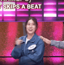 a woman in a blue denim jacket with a name tag that says ' t skips a beat '